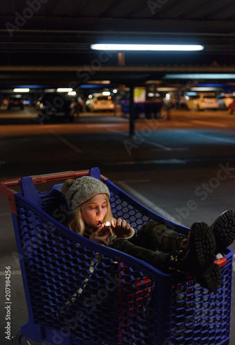 Woman smoking dope in shopping trolley photo