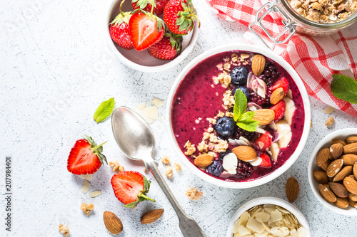 Smoothie bowl from fresh berries, nuts and granola.