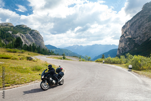 Motociclista in strada di montagna, curve e panorama