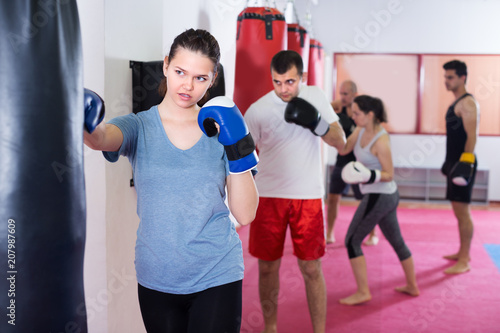 Girl is beating a boxing bag © JackF