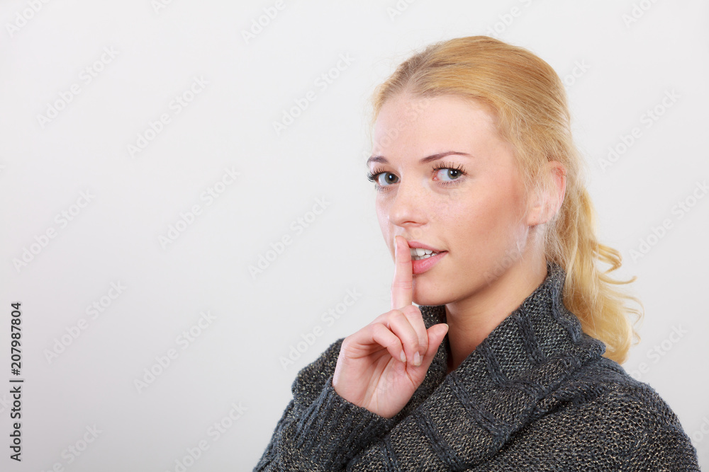 Woman holding finger close to lips, silence Woman holding finger close to lips, silence