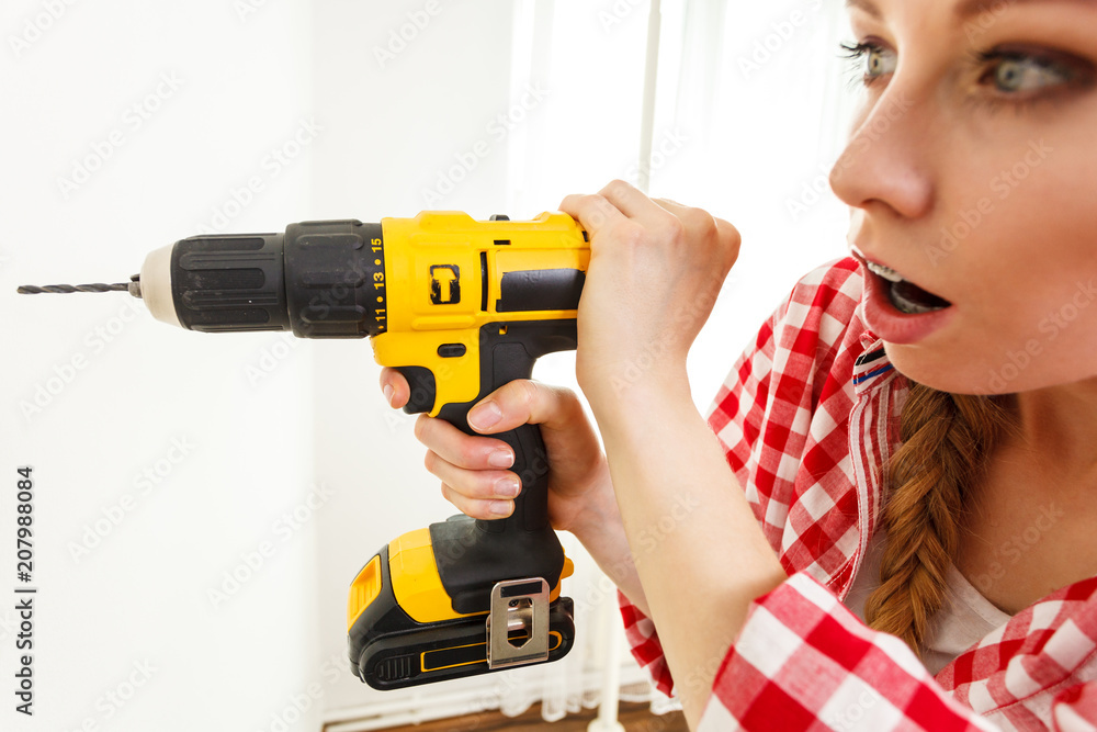 Woman having troubles using drill Woman having troubles using drill
