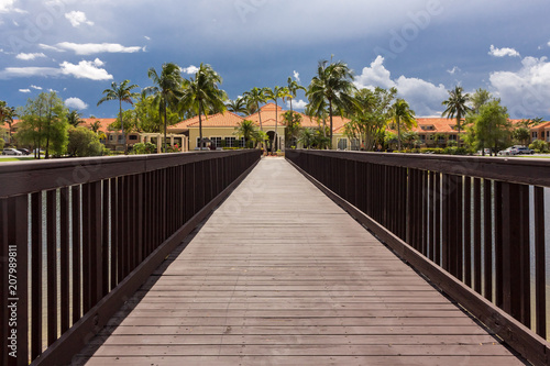 Puente de madera con casa y palmeras al final. punto de fuga © Anaid