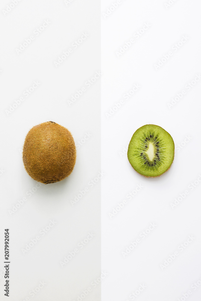 Obraz premium Fresh kiwi whole fruit and slice on grey white background