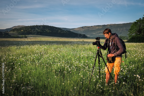 Photographer takes a pictures of a field with chamomiles