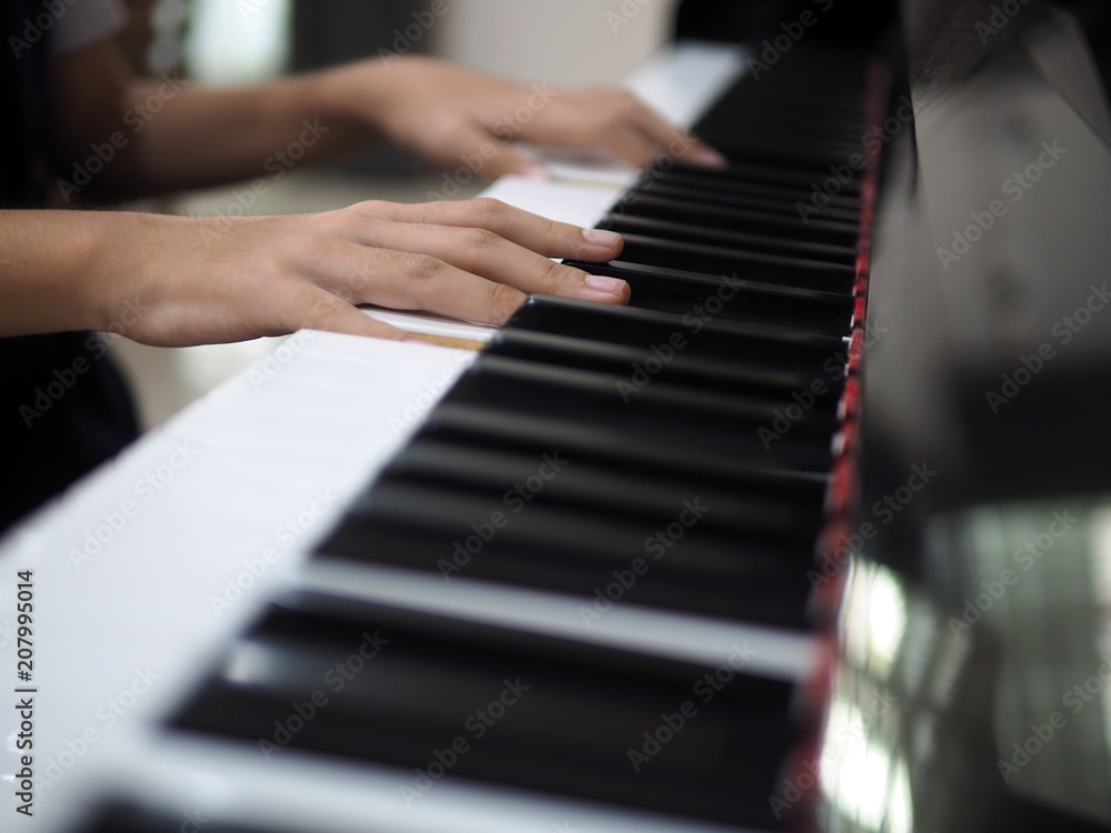 Obraz premium Close up of child hand on piano keys playing