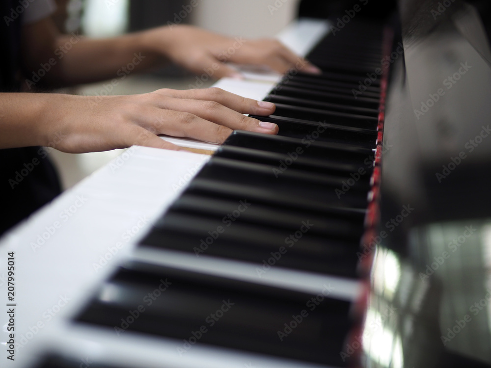 Close up of child hand on piano keys playing
