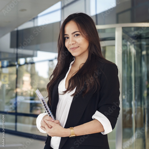 woman in suit holdig a copy book and smiling