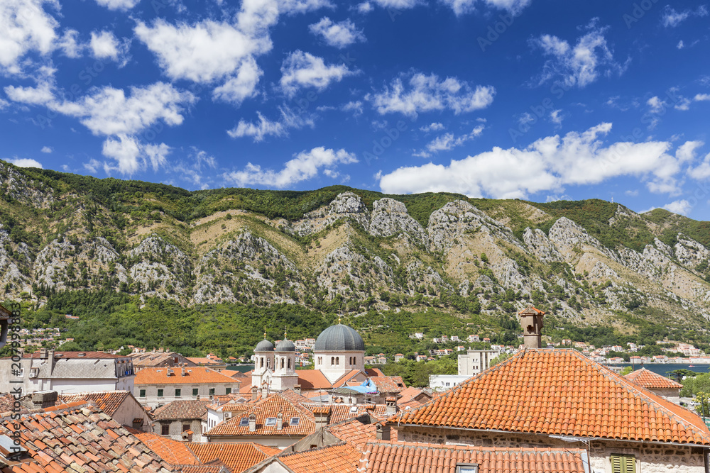 View of the tops of buildings and nearby mountains in Kotor, Montenegro.