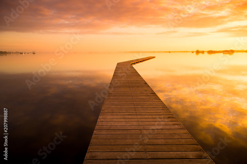 beautiful sunrise on a lake with a wooden dock