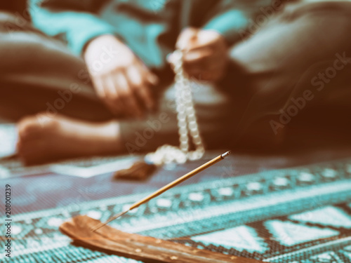 Canvas Print Concentrated woman praying with wooden rosary mala beads