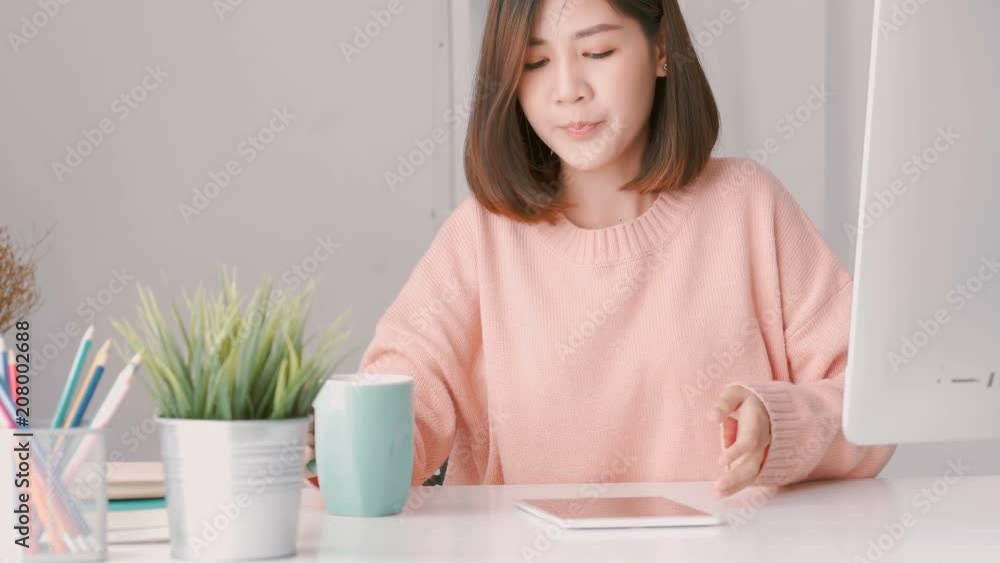 Young asian woman successful businesswoman using tablet at home office. Happy cheerful smiling. Young asian woman successful businesswoman using tablet at home office. Happy cheerful smiling.
