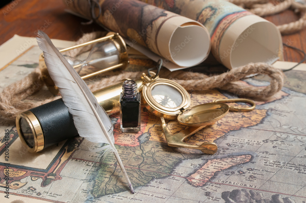 Quill pen and old papers on an old map with vintage items