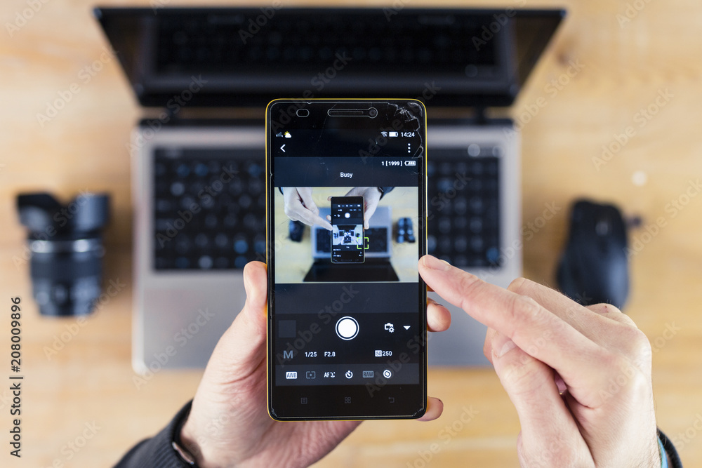 Smartphone in Hand and Laptop in Background Droste Effect Smartphone in Hand and Laptop in Background Droste Effect