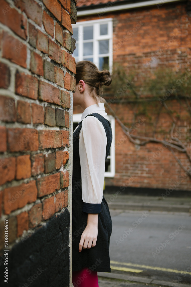 Young woman behind brick corner Young woman behind brick corner