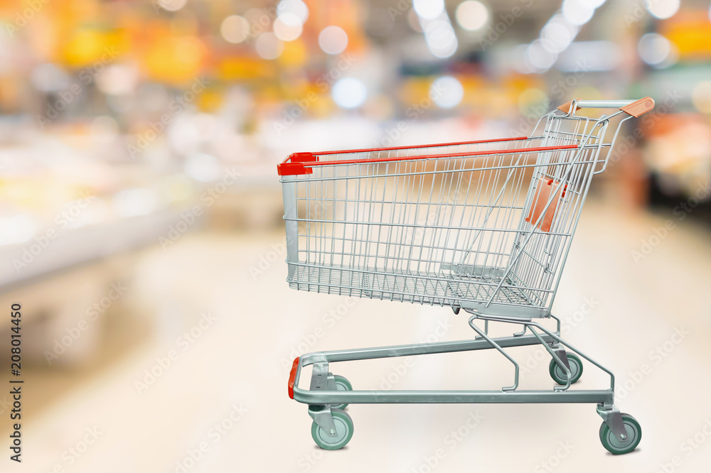Empty red shopping cart with Abstract supermarket grocery store blurred defocused background with bokeh light Empty red shopping cart with Abstract supermarket grocery store blurred defocused background with bokeh light