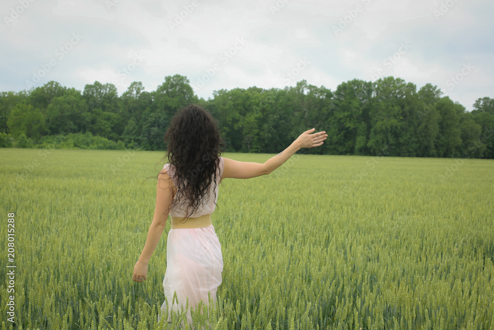 Woman Female Model in a Wheat Field Surrounded by Trees in Spring or Summer Wearing a Pink Flowing Dress Woman Female Model in a Wheat Field Surrounded by Trees in Spring or Summer Wearing a Pink Flowing Dress