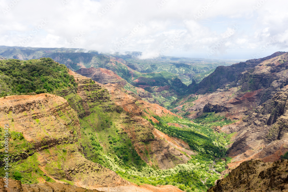 Aerial view on a sunny day over Waimea Canyon in Kauai, Hawaii - also known as The Grand Canyon of the Pacific