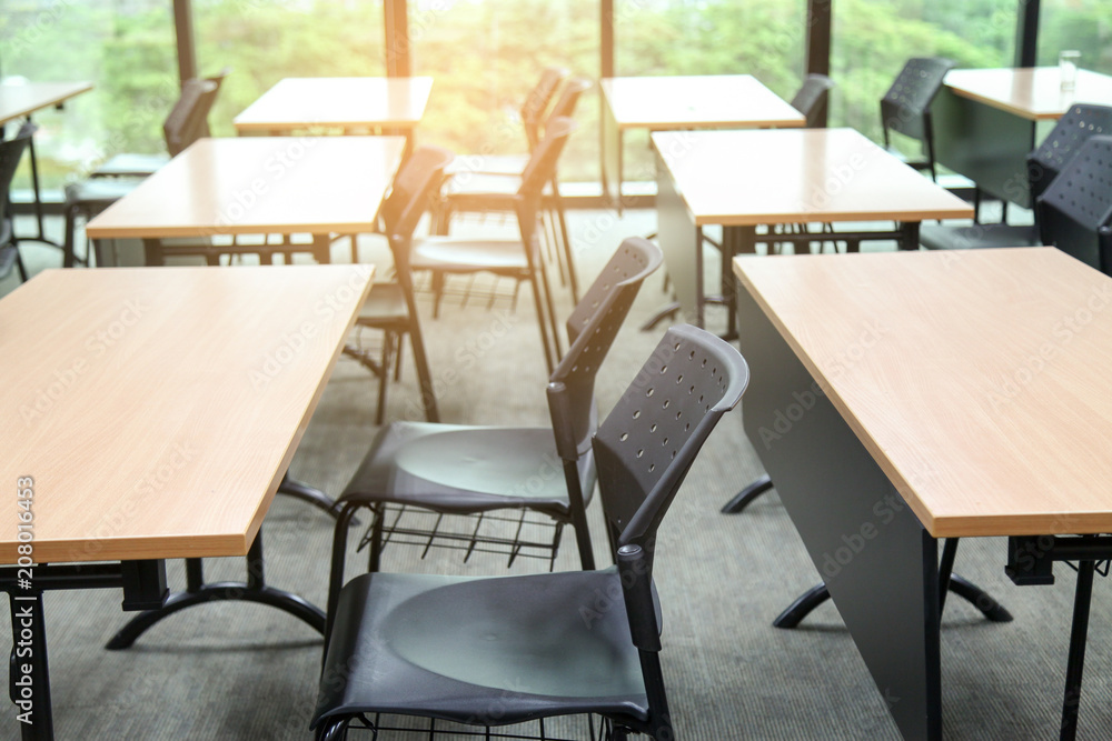 Table in a seminar room arranged in lined with chairs.