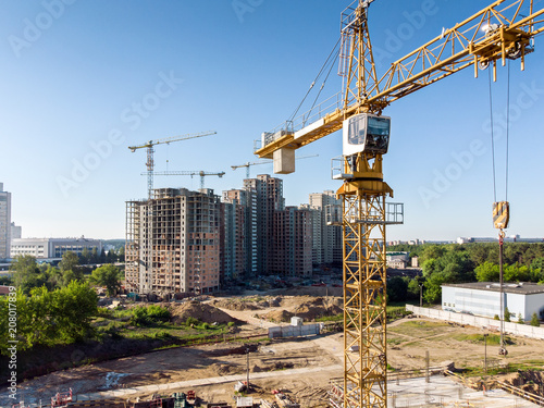 yellow tower crane on background of residential building construction