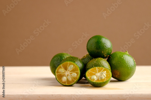 Calamansi on wooden table and brown background