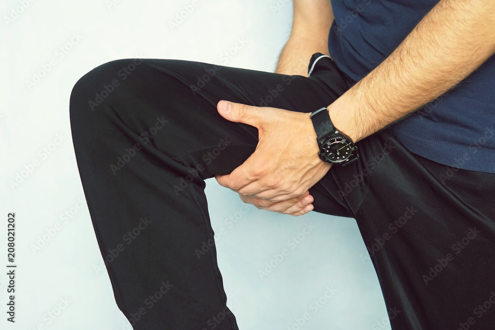 Muscle injury. Man with sprain thigh muscles. Athlete in sports shorts clutching his thigh