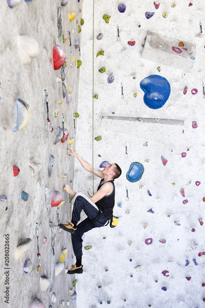 Young rock climber training on an indoor climbing wall Young rock climber training on an indoor climbing wall