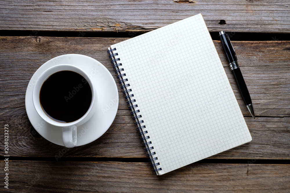 Notebook, pen and a cup of coffee on wooden table. Notebook, pen and a cup of coffee on wooden table.