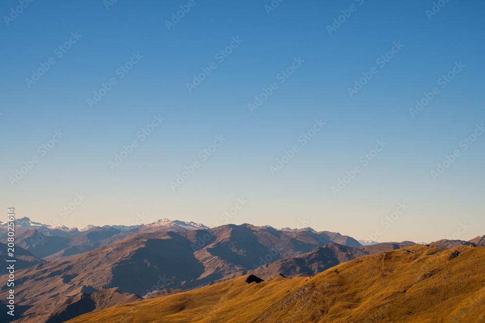 Beautiful landscape of a yellow grassland blue sky and Alps mountain at sunset.