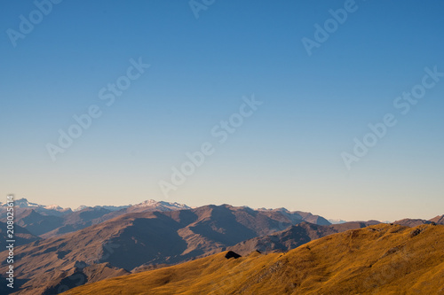Beautiful landscape of a yellow grassland blue sky and Alps mountain at sunset.