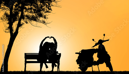 silhouette of lover couple and scooters on blurry sunset background.