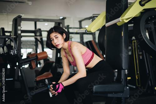 Attractive fit woman relaxing after workout in gym fitness. Portrait sport and Healthy concept.