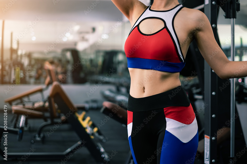 Beautiful fit woman in gym with equipment interior. Portrait sport and Healthy concept. Beautiful fit woman in gym with equipment interior. Portrait sport and Healthy concept.