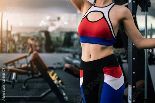Beautiful fit woman in gym with equipment interior. Portrait sport and Healthy concept.
