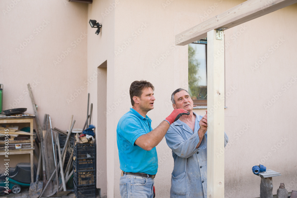 Men consulting about building wooden structure outdoor Men consulting about building wooden structure outdoor