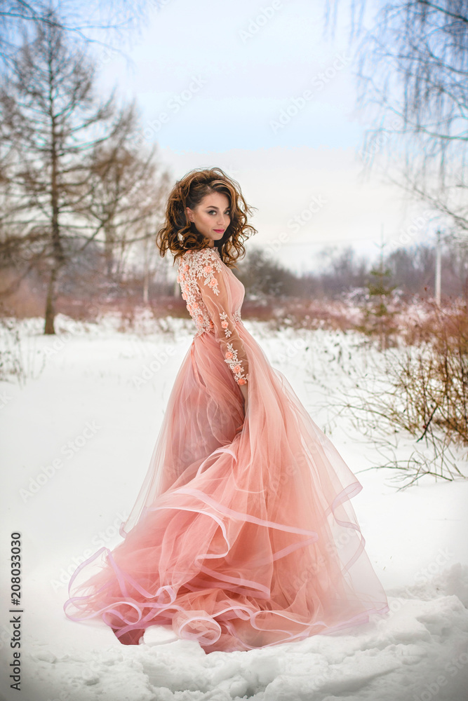 Girl in a beautiful pink dress in a winter forest Girl in a beautiful pink dress in a winter forest