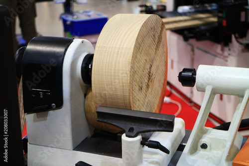 Cylindrical wooden workpiece is mounted on a lathe.