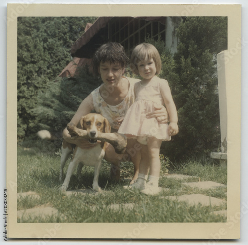 Vintage photo of young mother and toddler daughter with pet beagle  dog