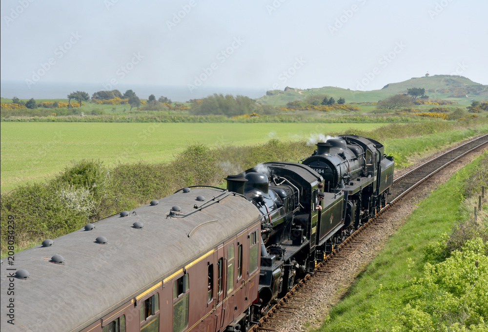 Steam engine through countryside on North Norfolk Railway
