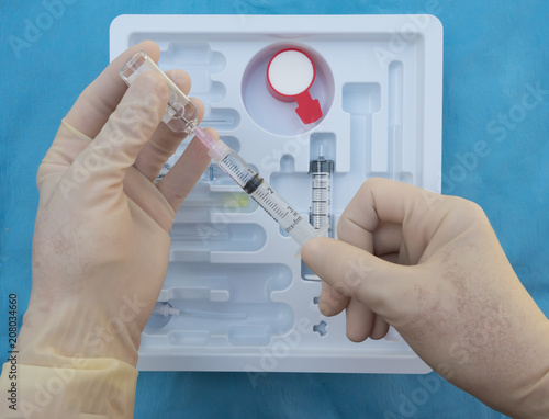 An Anesthesiologist Preparing an Injection of Local Anesthesia from a spinal anesthesia tray. photo