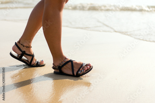 woman legs in shoes on the beach
