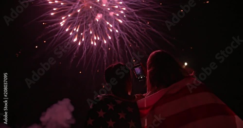Young people taking photos of fourth of July fireworks display
