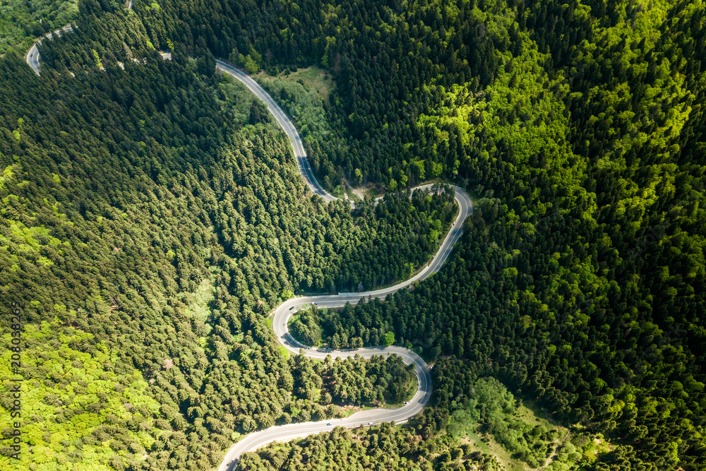Winding road from high mountain pass, in spring time. Aerial view by drone . Romania Winding road from high mountain pass, in spring time. Aerial view by drone . Romania