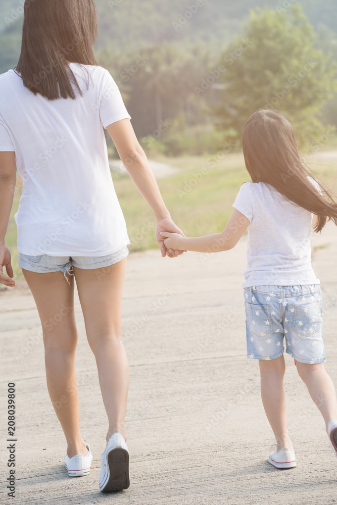the parent holds the hand of a small child the parent holds the hand of a small child