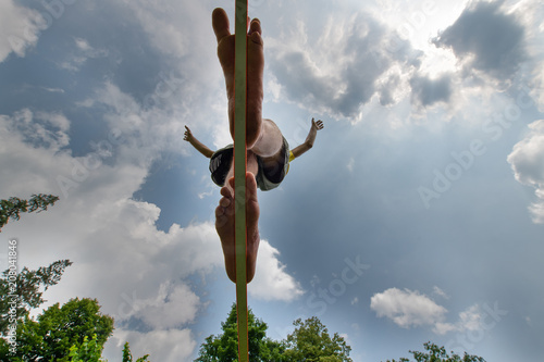 Slackline. a barefoot boy walking on a webbing in balance photo