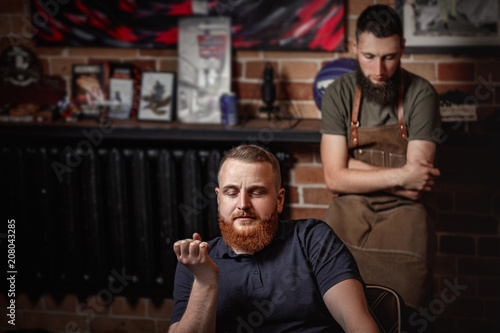 Barber and bearded man in barber shop