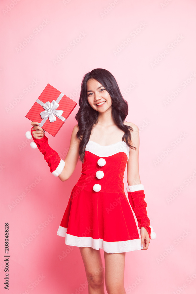 Fototapeta premium Portrait of cute Asian Christmas Santa Claus girl with red gift box