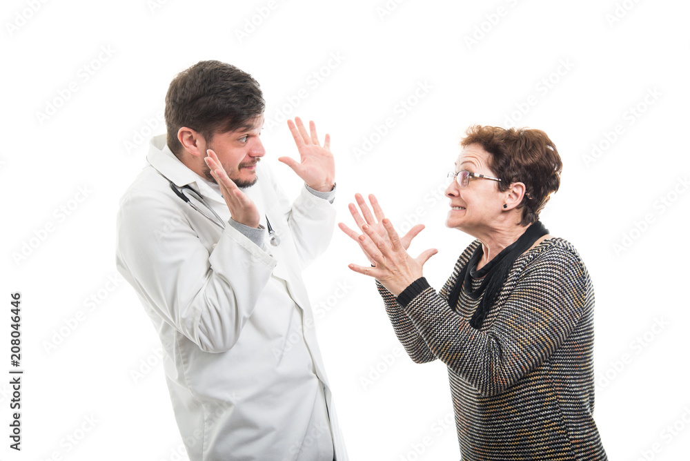 Female senior patient fighting with male doctor Female senior patient fighting with male doctor