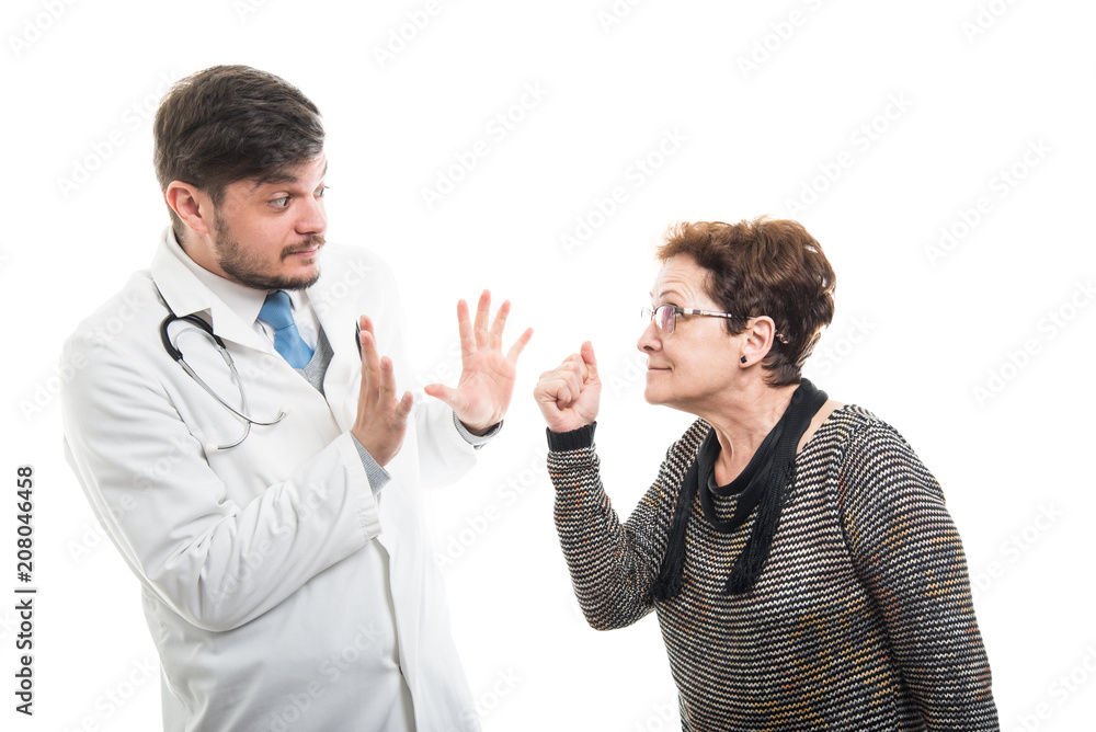 Female senior patient showing fist to male doctor Female senior patient showing fist to male doctor
