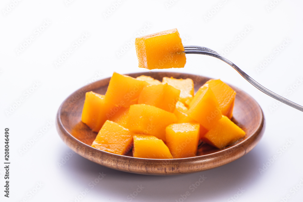 Fresh and beautiful mango in a wooden plate with sliced diced mango chunks isolated with   white background, copy space(text space), blank for text